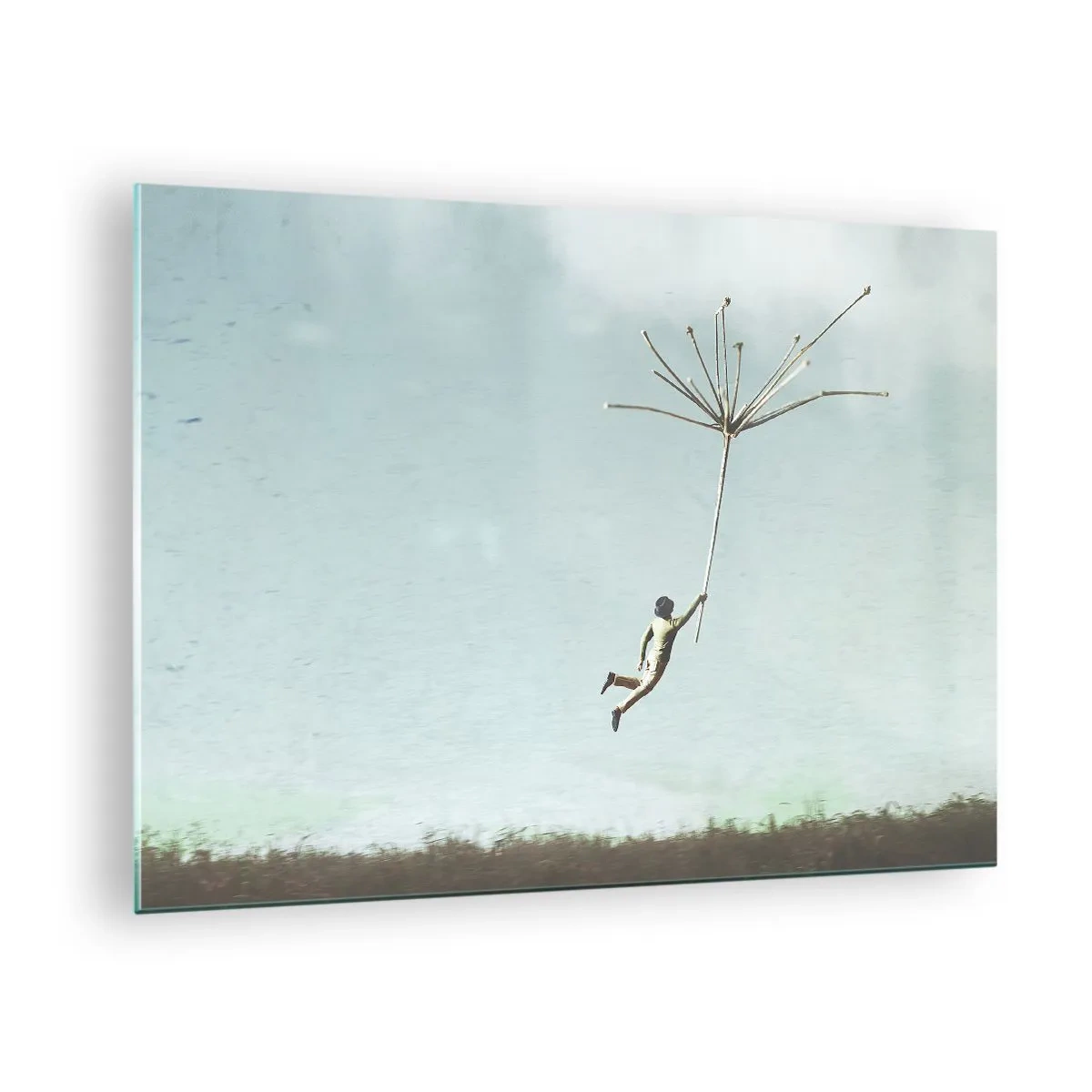 Üveg kép - Egy fiú pitypangmaggal repül a rét felett - 70x50cm - Sárkányrepülők, pitypangok, szél - Modern fali dekoráció nappalihoz és hálószobához ARTTOR