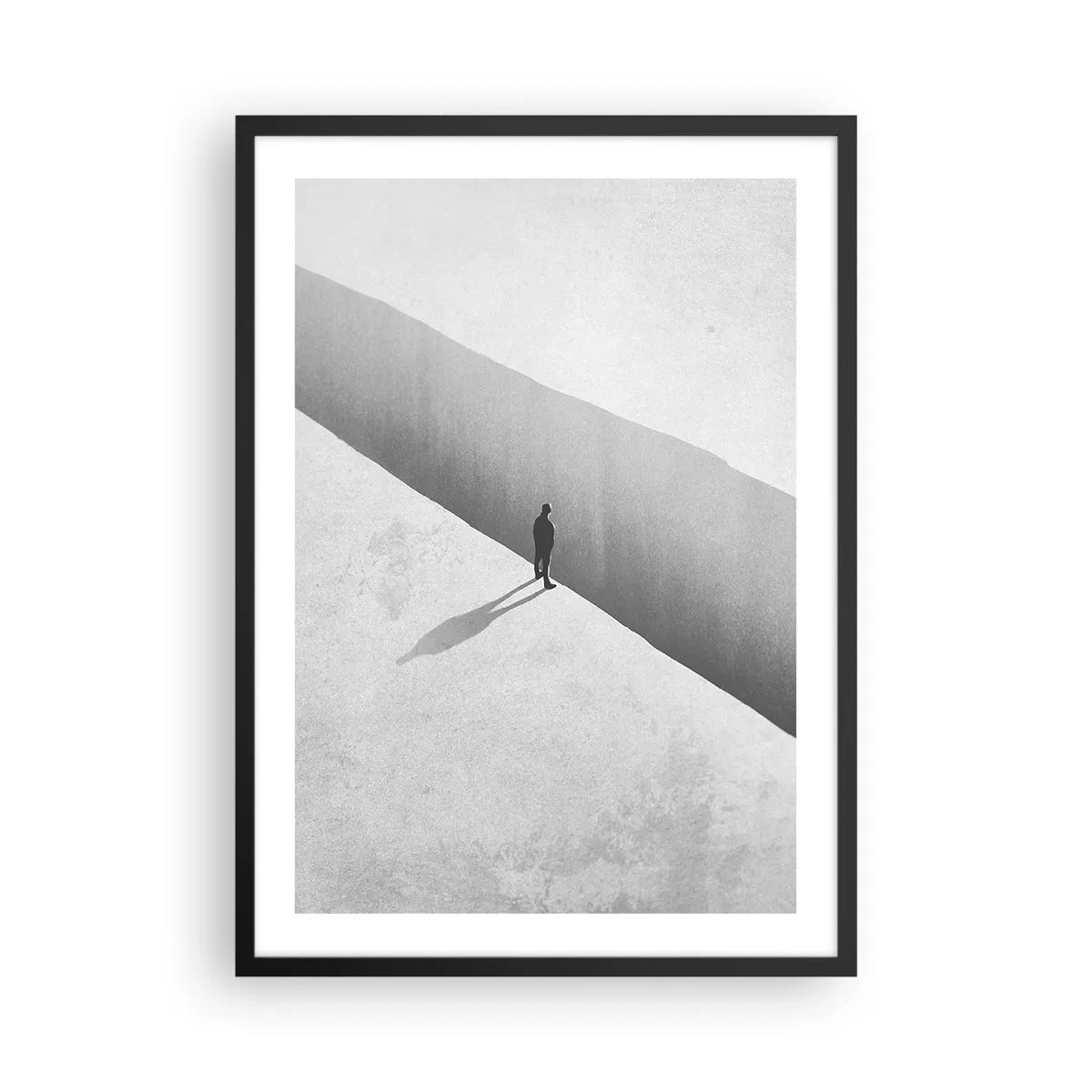 Poszter fehér keretben - Egy alak áll egy szakadék felett monokróm környezetben - 50x70cm - Fényes célpont - Modern fali dekoráció nappalihoz és hálószobához ARTTOR