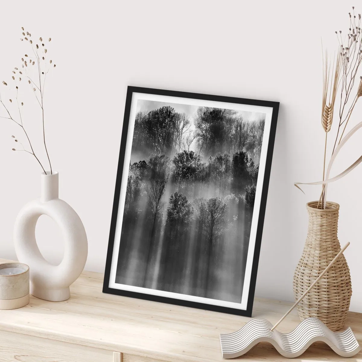Poszter fehér keretben - Fekete-fehér erdő a ködben, napsugarakkal - 50x70cm - Fénypatakokban - Modern fali dekoráció nappalihoz és hálószobához ARTTOR